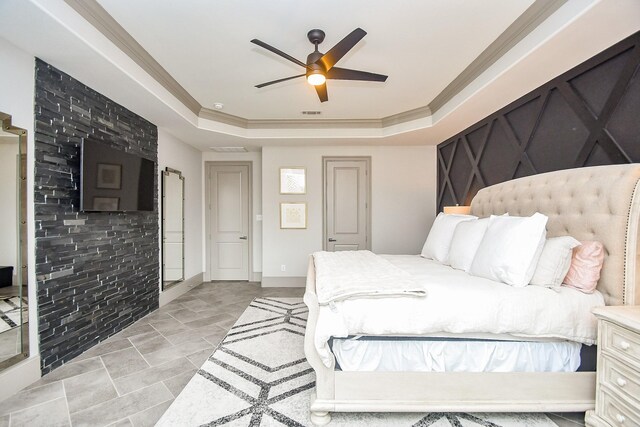 bedroom featuring a tray ceiling, ornamental molding, and ceiling fan