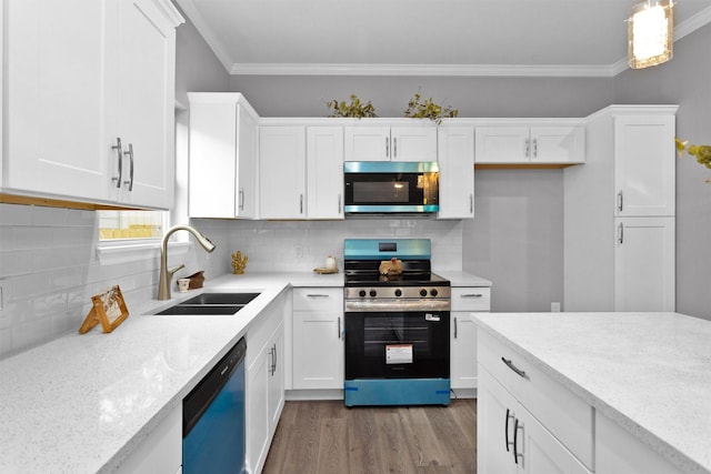 kitchen with appliances with stainless steel finishes, a sink, white cabinets, and ornamental molding