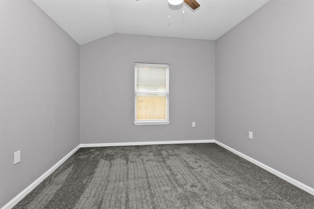 carpeted spare room with ceiling fan, vaulted ceiling, and baseboards