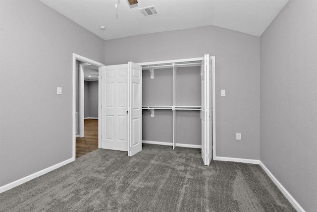 unfurnished bedroom featuring carpet, vaulted ceiling, baseboards, a closet, and a ceiling fan
