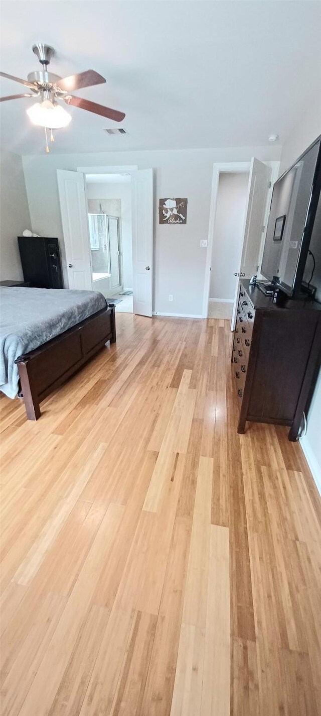 bedroom with light wood-style flooring, ceiling fan, and baseboards