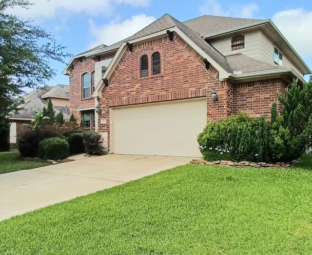 traditional-style house featuring brick siding, driveway, a front yard, and roof with shingles