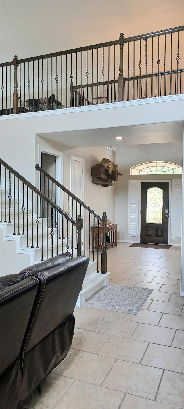 foyer entrance featuring a towering ceiling and stairway
