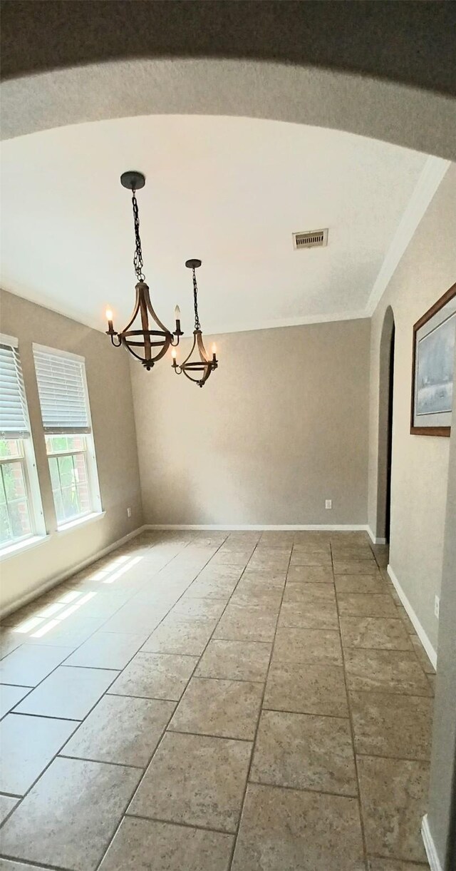 unfurnished room with a chandelier, arched walkways, baseboards, and ornamental molding