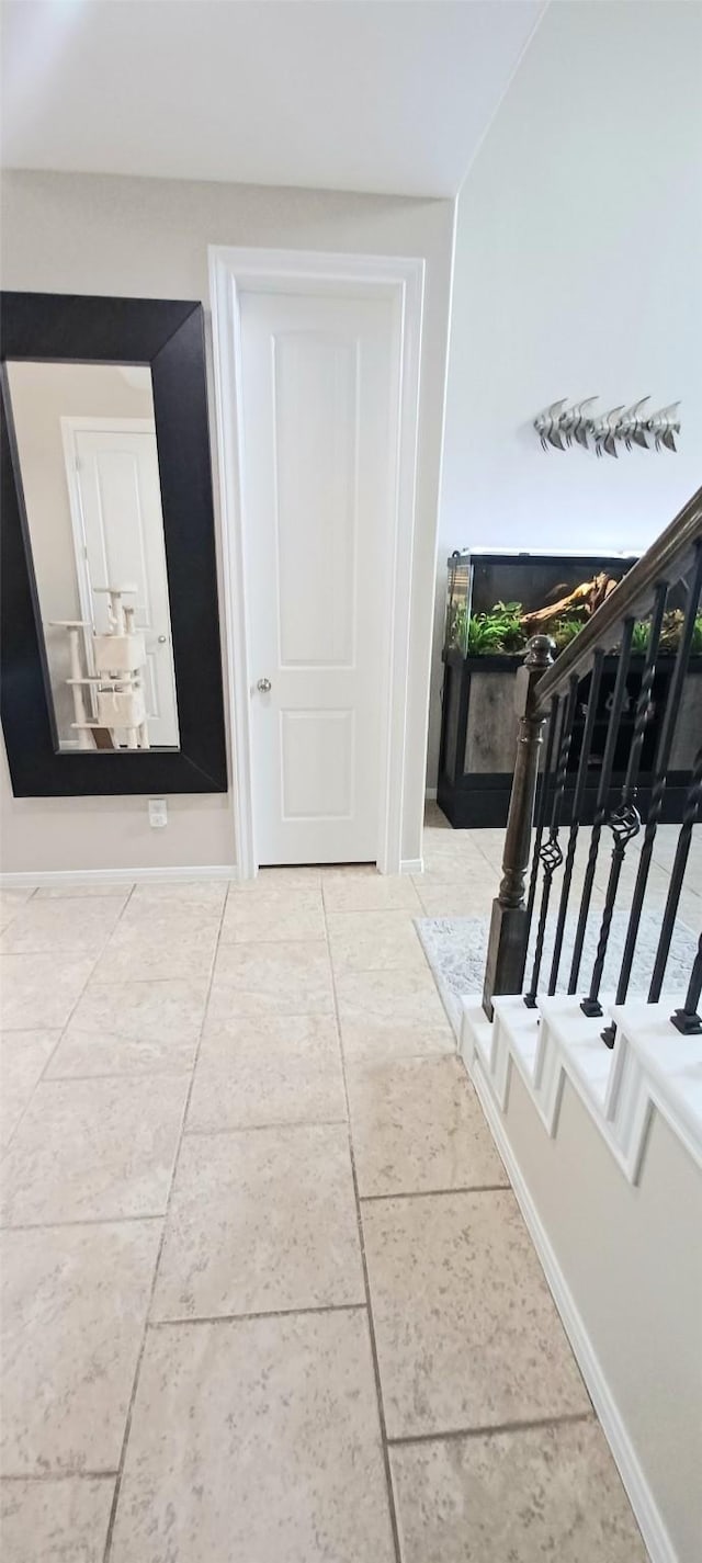 hall with tile patterned floors