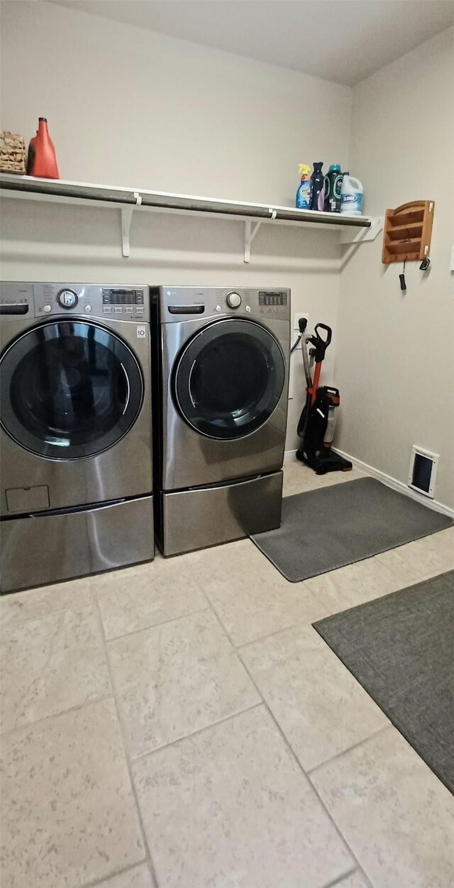 washroom featuring washing machine and clothes dryer and tile patterned floors