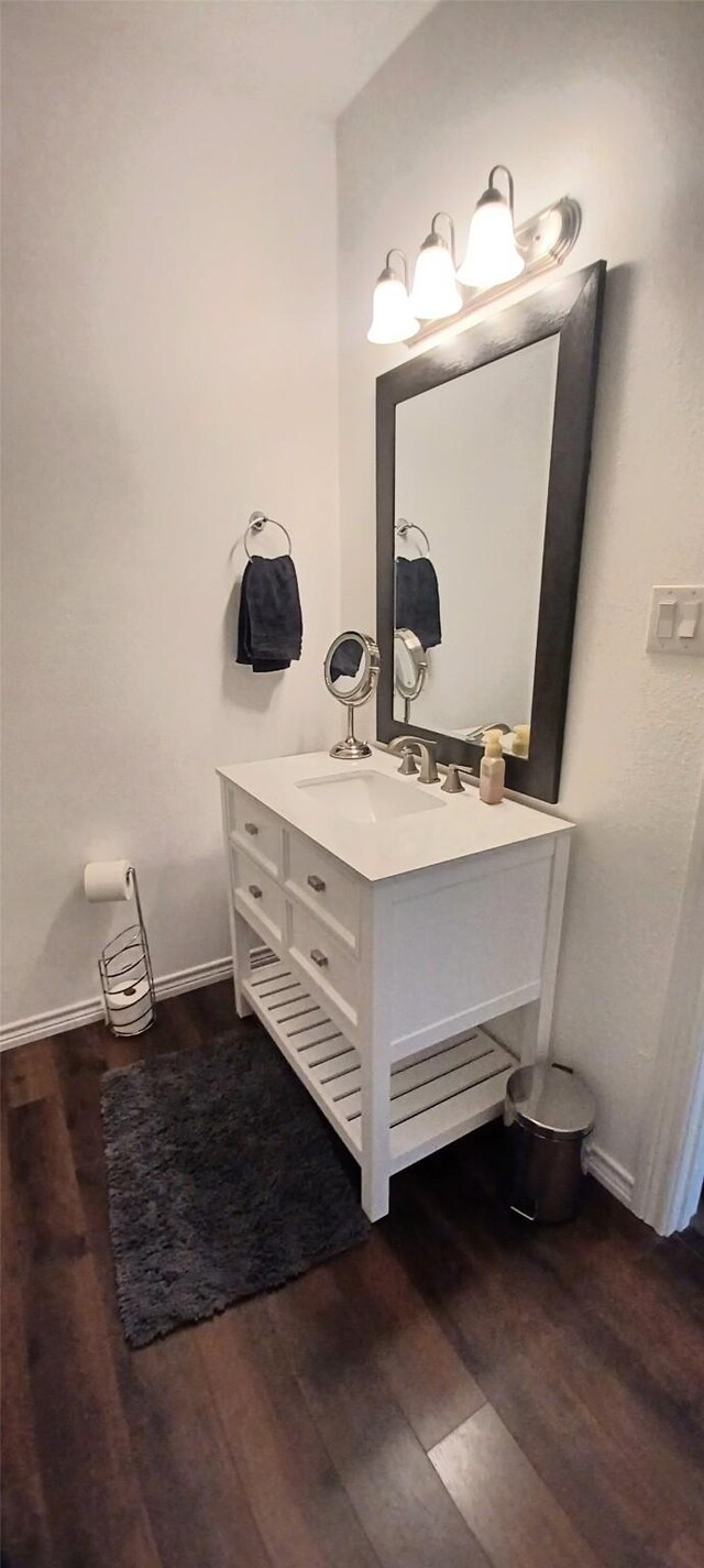 bathroom with wood finished floors, vanity, and baseboards