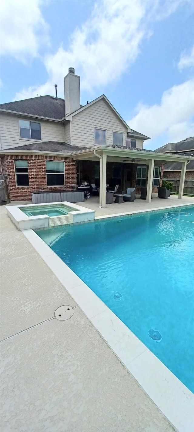 view of pool with a patio, outdoor lounge area, and a pool with connected hot tub