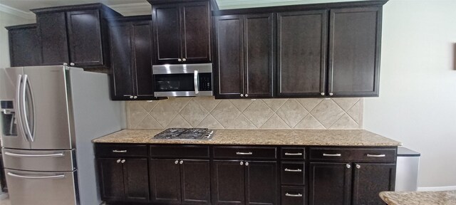 kitchen with stainless steel appliances, backsplash, baseboards, crown molding, and light stone counters