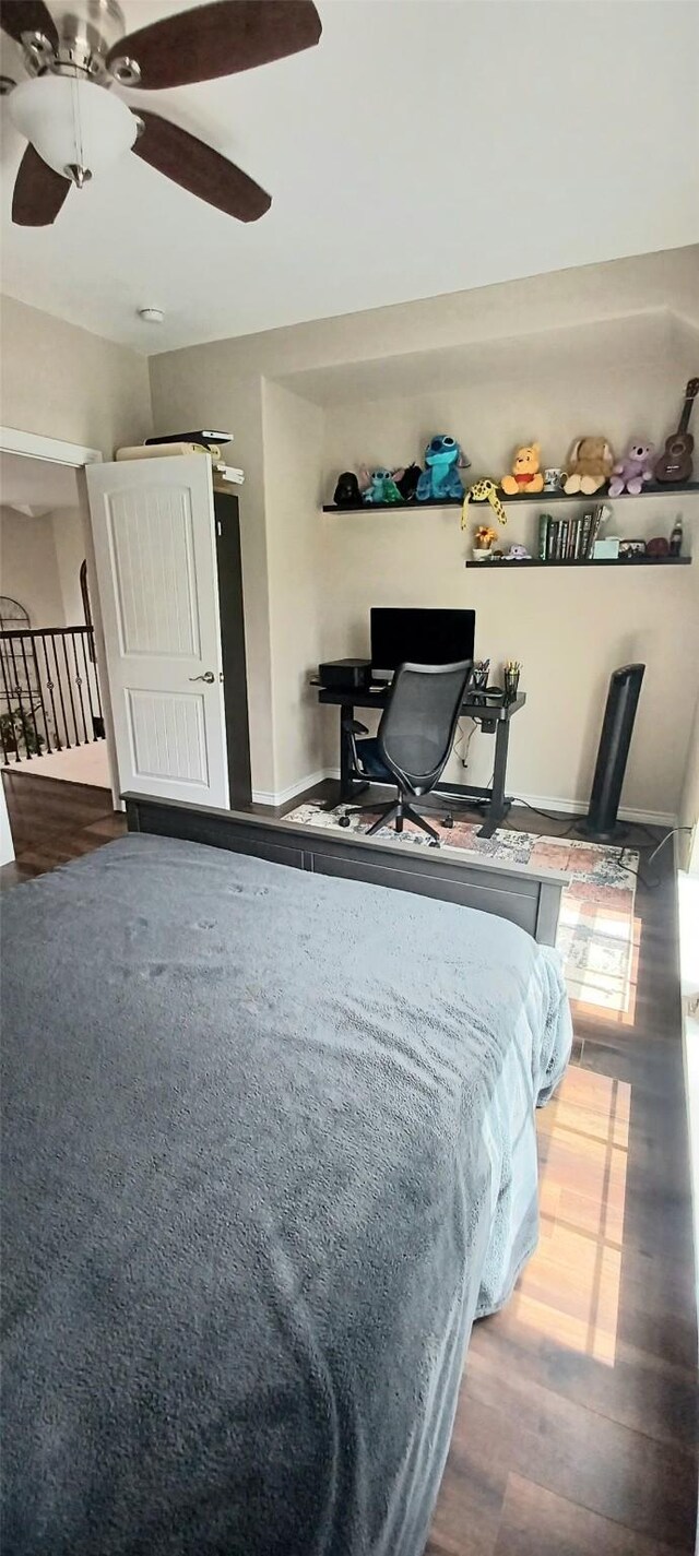 bedroom with a desk, wood finished floors, and a ceiling fan