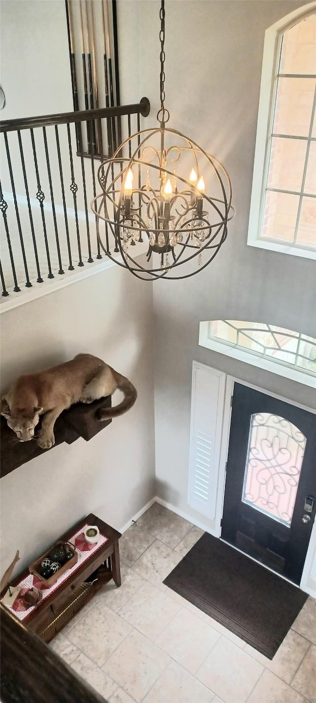 foyer featuring a chandelier and baseboards