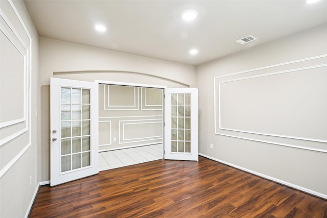 empty room featuring wood finished floors, recessed lighting, baseboards, and french doors