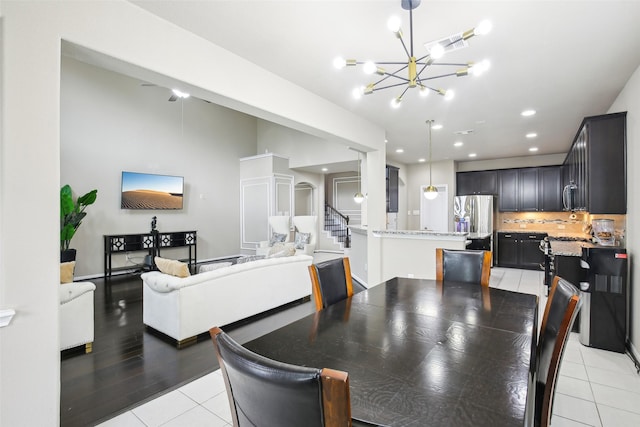 dining area with light tile patterned flooring, a chandelier, stairway, and recessed lighting