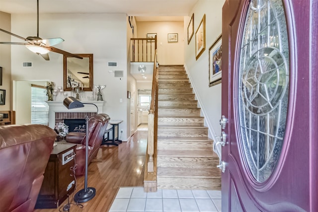 15223 Hillside Park Way, Cypress, TX 77433 - foyer entrance with ceiling fan, stairway, a brick fireplace, a high ceiling, and tile patterned flooring