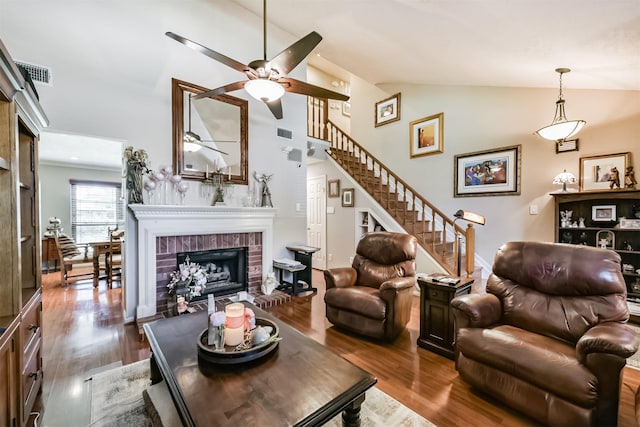 15223 Hillside Park Way, Cypress, TX 77433 - living area featuring a ceiling fan, wood finished floors, a fireplace, stairs, and high vaulted ceiling