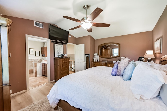 15223 Hillside Park Way, Cypress, TX 77433 - bedroom with vaulted ceiling, light wood-type flooring, a ceiling fan, and connected bathroom