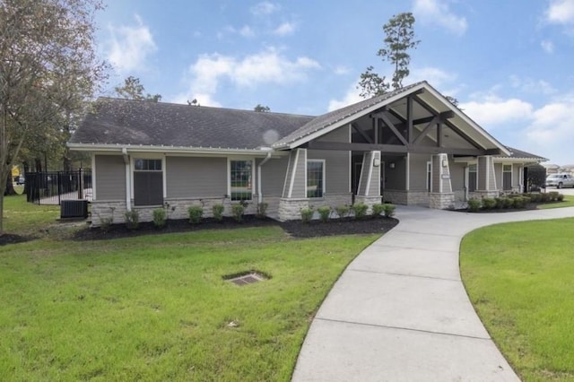 15335 Oakheath Colony Ln, Houston, TX 77044 - view of front of home featuring stone siding, covered porch, cooling unit, and roof with shingles