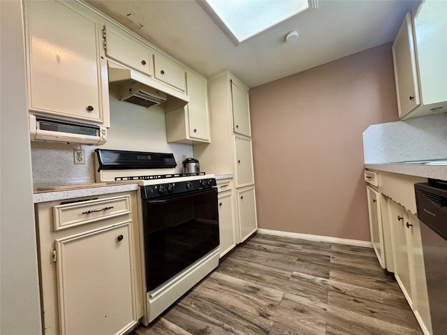 13642 Greenridge Dr, Sugar Land, TX 77498 - kitchen with range with gas stovetop, under cabinet range hood, light countertops, wood finished floors, and white cabinets