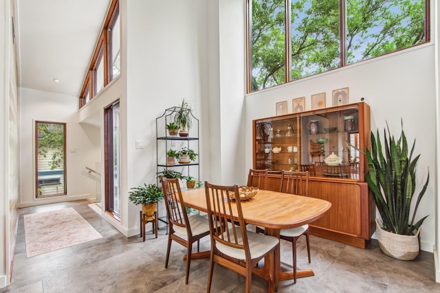 dining area with a towering ceiling and baseboards