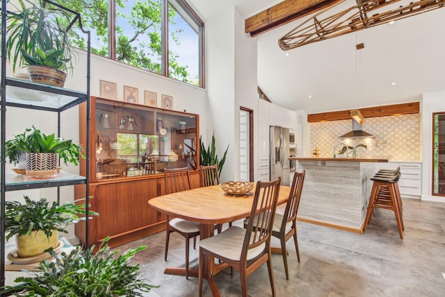 dining area featuring beamed ceiling and high vaulted ceiling