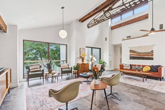 living room featuring high vaulted ceiling, plenty of natural light, a ceiling fan, concrete flooring, and baseboards