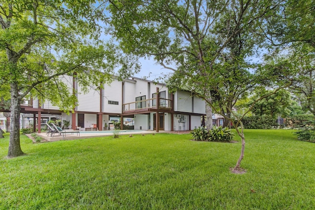 back of property with a yard, a patio area, and an outdoor pool
