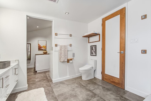 bathroom featuring baseboards, toilet, and vanity