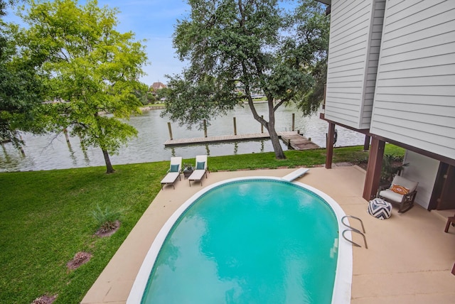 swimming pool featuring a water view, a yard, a patio, and a dock