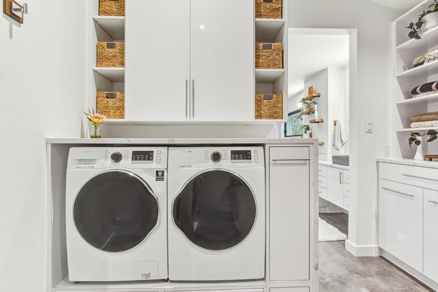 laundry room featuring independent washer and dryer and cabinet space