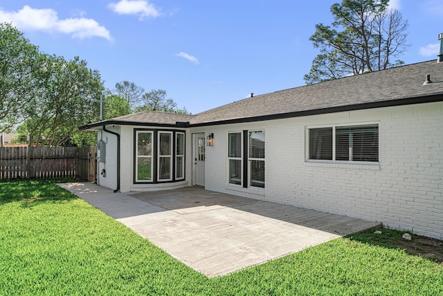 back of house featuring brick siding, a shingled roof, and a patio area