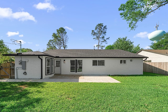 rear view of house with brick siding, a patio, and roof with shingles