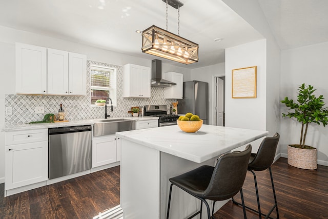 kitchen with appliances with stainless steel finishes, wall chimney range hood, a sink, and decorative backsplash