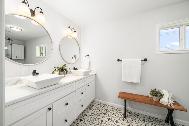 full bath with baseboards and double vanity