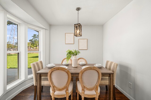 dining area featuring dark wood-style flooring and baseboards