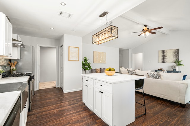 kitchen featuring a kitchen bar, open floor plan, dark wood-style flooring, stainless steel appliances, and ceiling fan