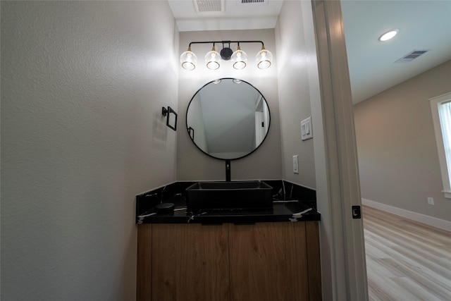 bathroom featuring wood finished floors, baseboards, and vanity