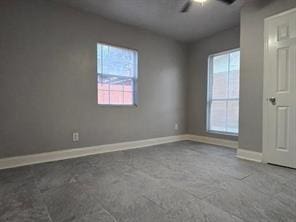 spare room with a ceiling fan, carpet, and baseboards