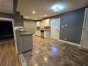 kitchen featuring dark countertops, recessed lighting, dishwasher, and baseboards