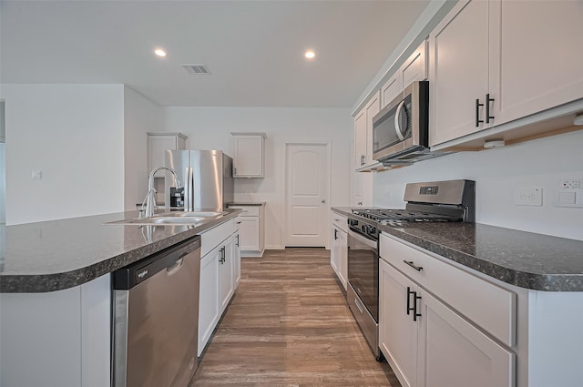 5422 Evergreen Heights Ln, Spring, TX 77373 - kitchen with appliances with stainless steel finishes, a sink, wood finished floors, dark countertops, and recessed lighting