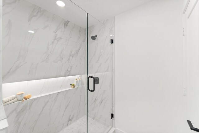bathroom featuring a marble finish shower and recessed lighting