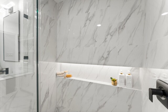 full bathroom featuring a marble finish shower