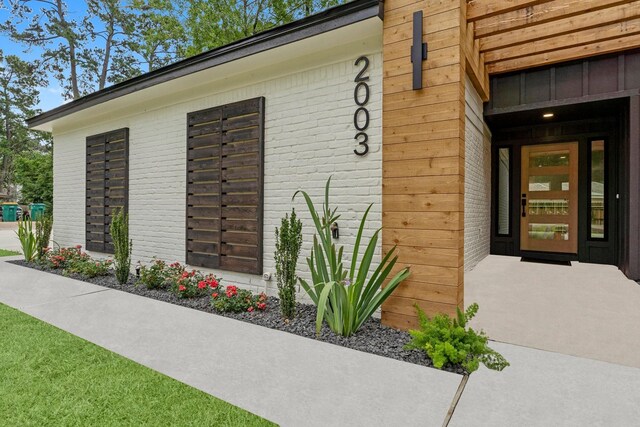 doorway to property featuring brick siding