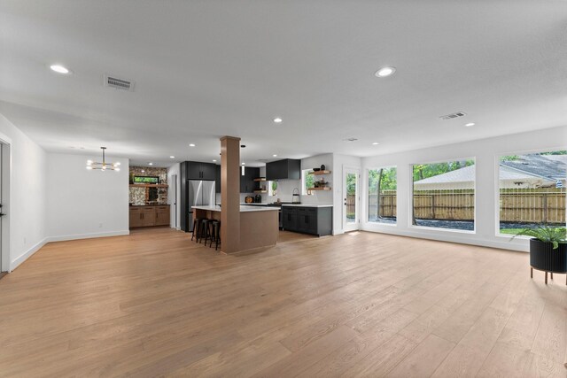 2003 Longstraw Pl, The Woodlands, TX 77380 - unfurnished living room with a chandelier, light wood-type flooring, recessed lighting, and baseboards