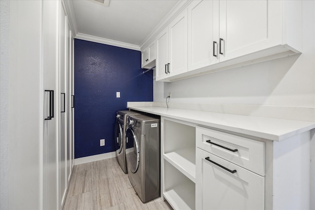 clothes washing area with washer and clothes dryer, cabinet space, baseboards, crown molding, and light wood-style floors