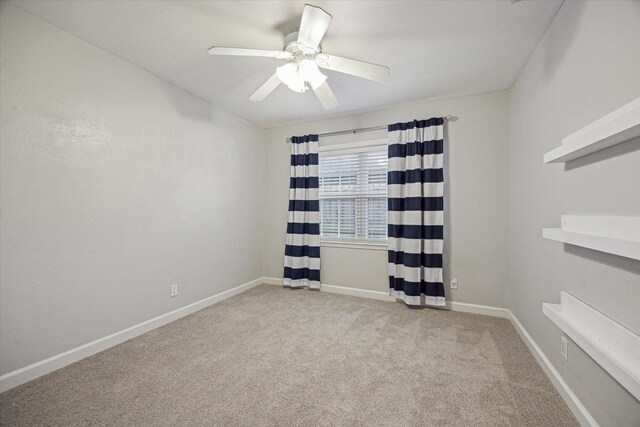 spare room featuring carpet, ceiling fan, and baseboards