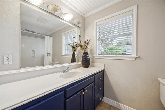 bathroom with toilet, crown molding, vanity, and baseboards
