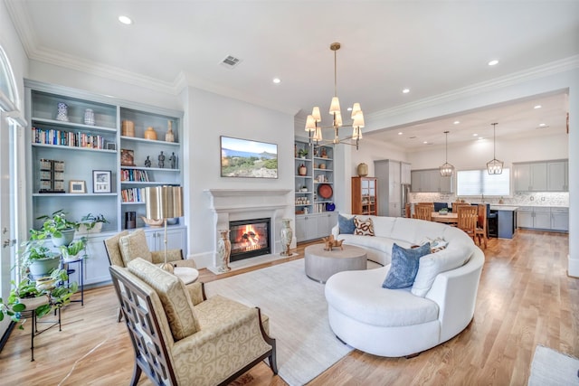 7119 Janet St, Houston, TX 77055 - living room with a chandelier, a fireplace with flush hearth, light wood-style floors, recessed lighting, and built in features