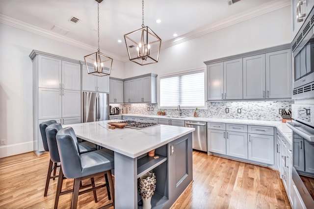 7119 Janet St, Houston, TX 77055 - kitchen with stainless steel appliances, gray cabinetry, ornamental molding, a sink, and a chandelier
