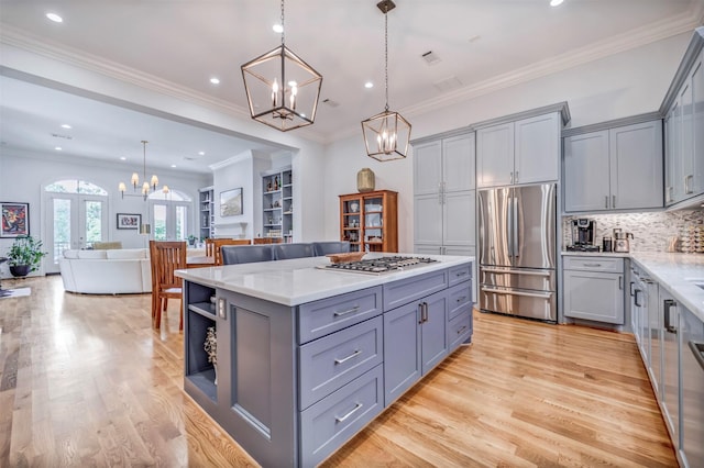 7119 Janet St, Houston, TX 77055 - kitchen featuring appliances with stainless steel finishes, gray cabinetry, a chandelier, light wood-type flooring, and recessed lighting
