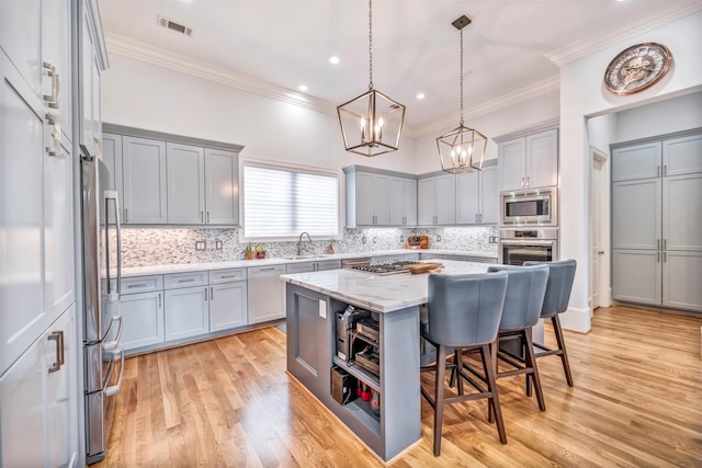 7119 Janet St, Houston, TX 77055 - kitchen with appliances with stainless steel finishes, gray cabinets, crown molding, a chandelier, and a sink
